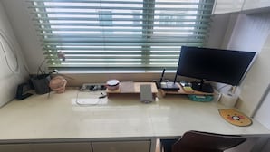Un escritorio con un monitor de computadora, teclado y varios útiles de oficina.