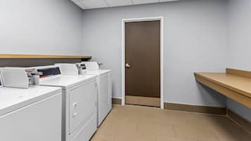 A laundry room with a washing machine, dryer, and a control panel.