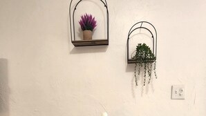 Une table à manger ornée d’un vase de fleurs blanches, de deux assiettes et de deux verres. Deux bancs sont placés devant la table.