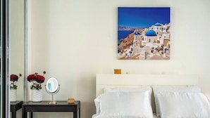 A hotel room with a bed, a bedside table with a mirror, and a vase with flowers. - Studio 3 minutes to the airport| Free Parking|Pool (Carolina)