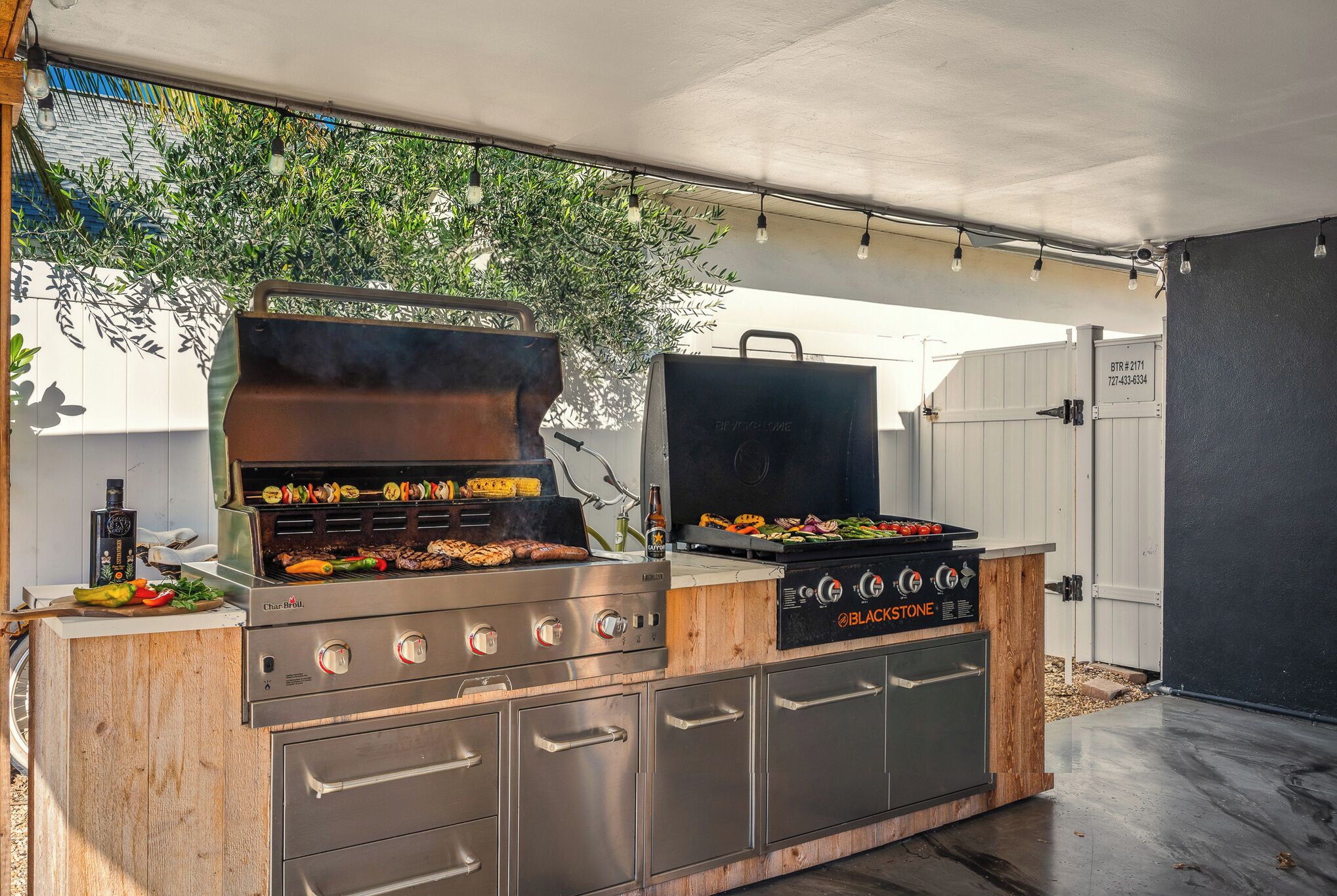 Una cocina al aire libre con una parrilla, horno empotrado y pileta.