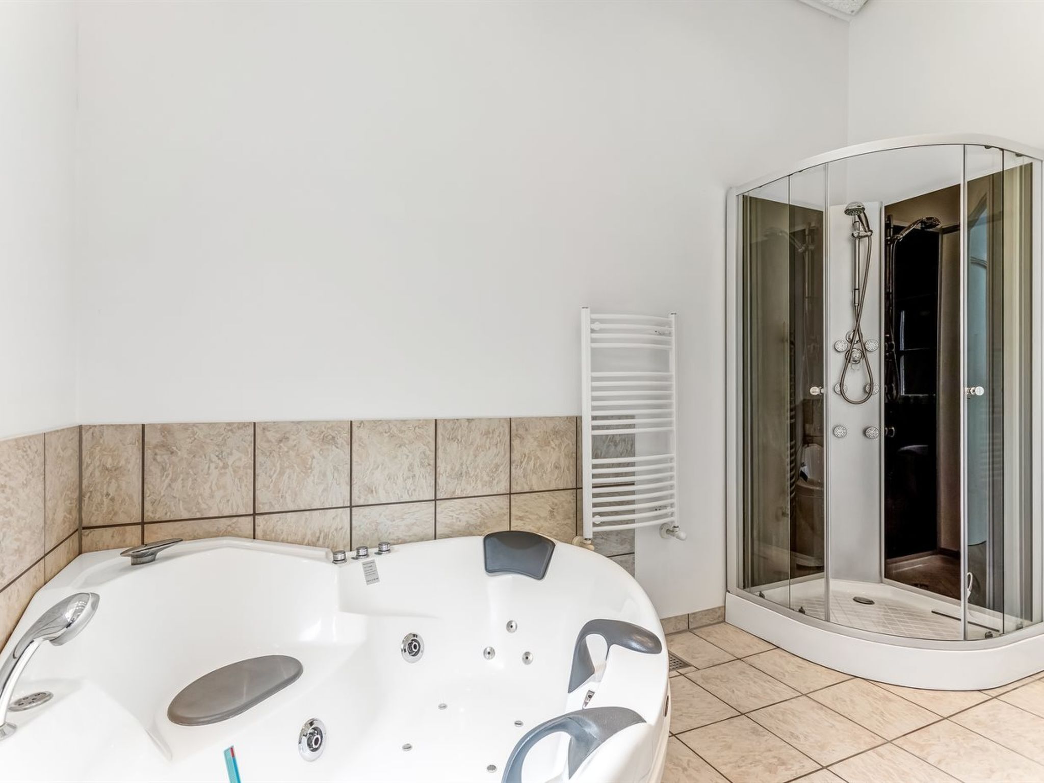 A modern bathroom with a freestanding bathtub, a glass-enclosed shower, and a towel rack.