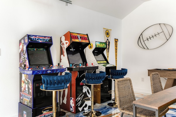 Game room with Golden Tee, NFL Blitz, NBA Jam, big screen tv, and shuffleboard