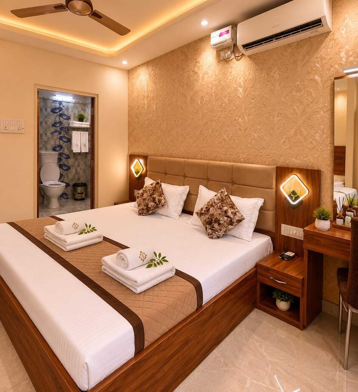 A hotel room with a large bed, a bedside table, a mirror, and an air conditioning unit.