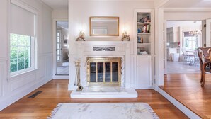 A room with a fireplace, white walls, and wooden flooring. - Amish Country Getaway w/ Hot Tub & Views (Applecreek)