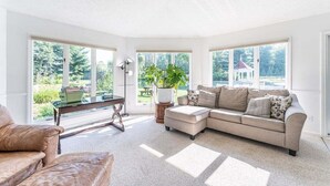 A spacious living room with a large sectional sofa, a coffee table, and a potted plant. - Amish Country Getaway w/ Hot Tub & Views (Applecreek)