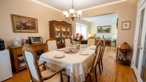 A dining area with a table set for four, surrounded by wooden chairs, a vintage globe, and a cabinet with glass doors. - Private Room Honey Room 15 MINS WALK to Falls (Niagara Falls)