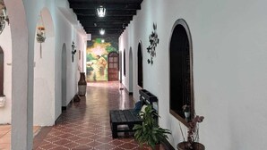 A corridor with patterned floor tiles, white walls, and wooden beams on the ceiling. - Casa Quetzalli Los Nazarenos (Antigua Guatemala)