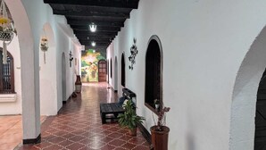 A corridor with a patterned floor, white walls, and arches. - Casa Quetzalli Los Nazarenos (Antigua Guatemala)