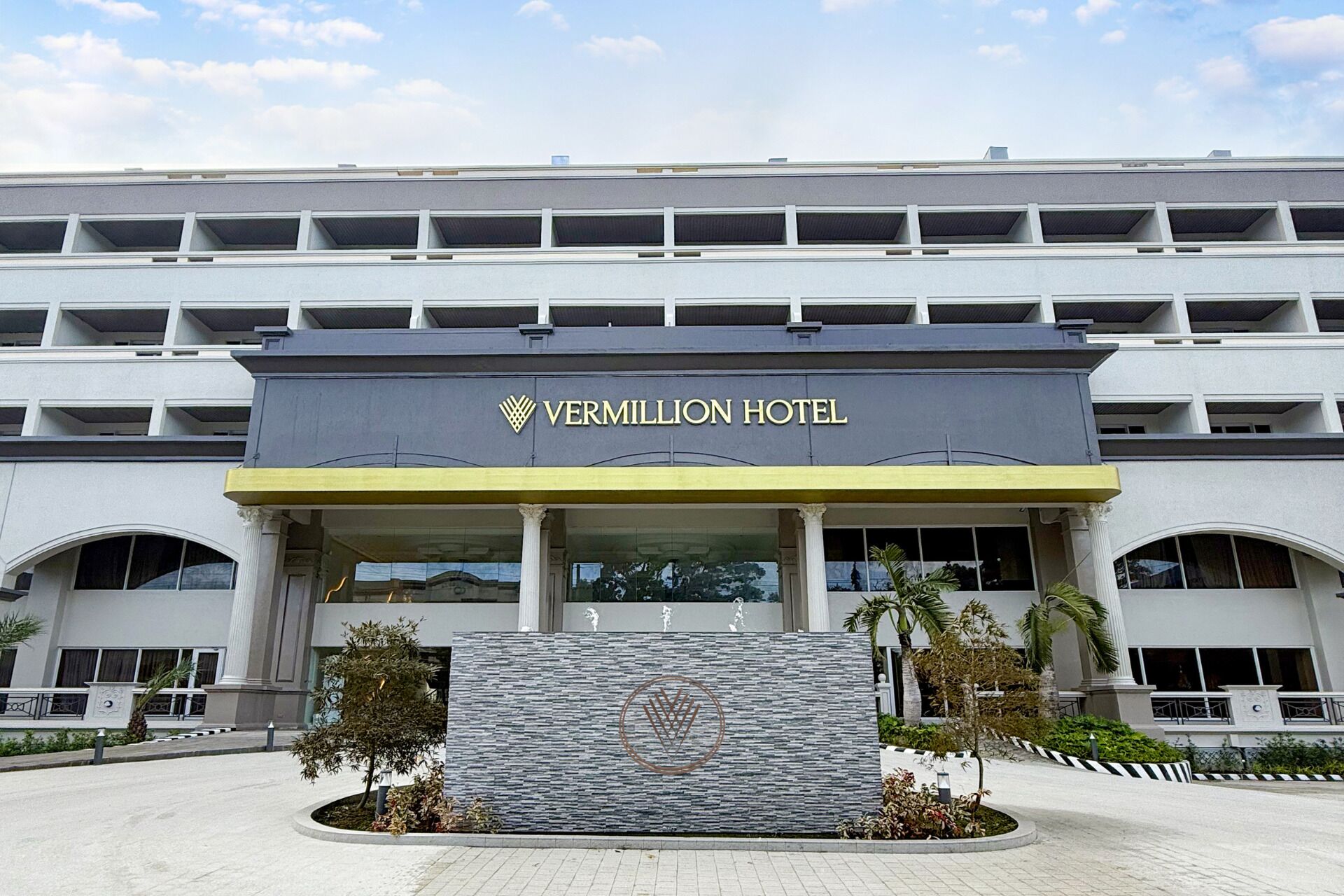 The exterior of the Vermillion Hotel with a modern architectural design, featuring a prominent entrance and a landscaped area in front.