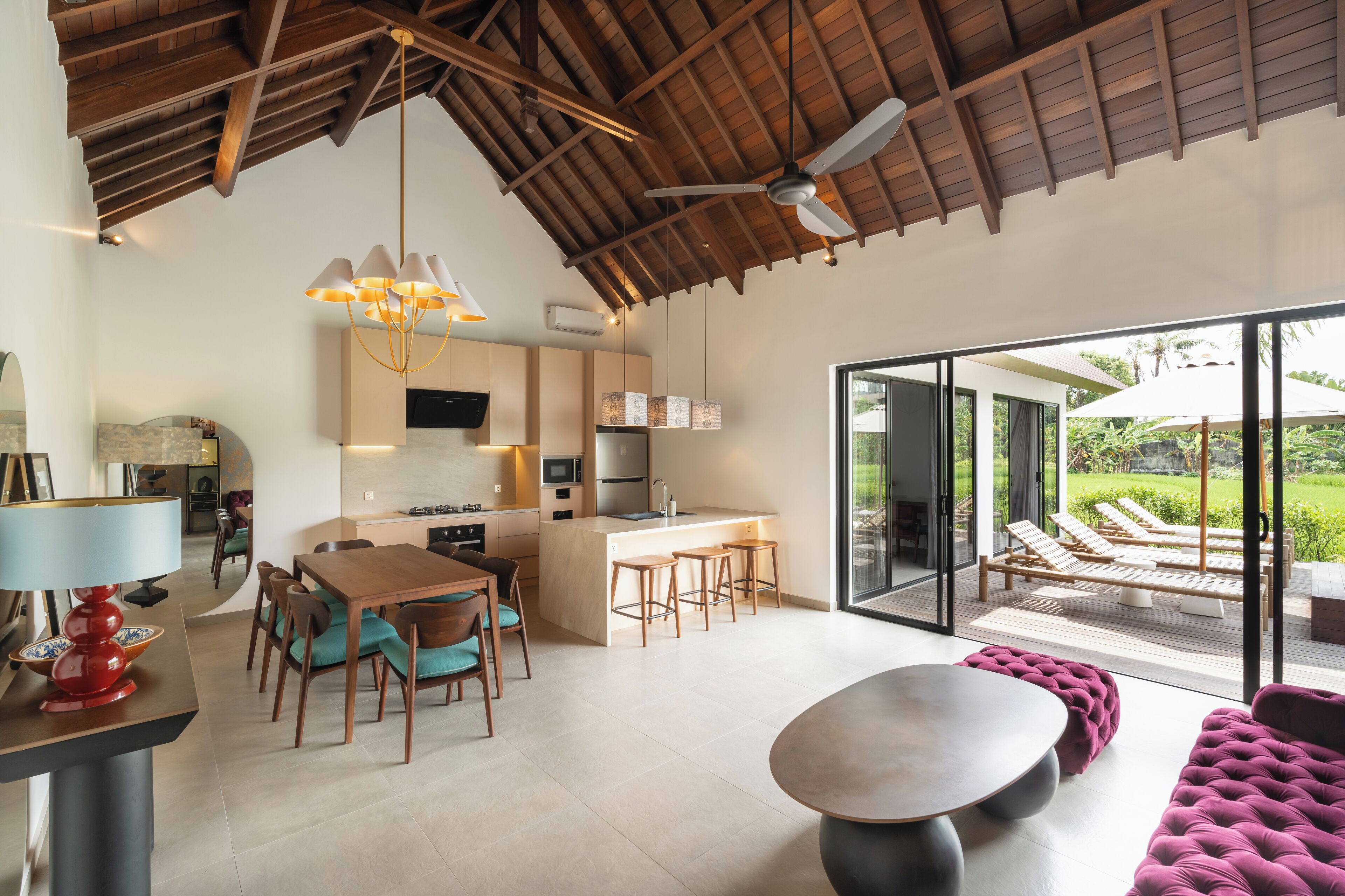 A spacious living area with a dining table, a sofa, and a kitchen area with a bar.