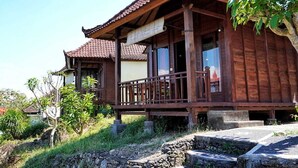 Una casa tradicional de madera con tejado de tejas, un balcón y un camino de piedra que conduce a la entrada.