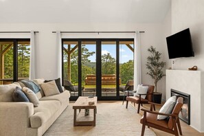 A modern living room with a sofa, chairs, a coffee table, and a fireplace.