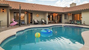 A swimming pool with lounge chairs and a flamingo decoration.
