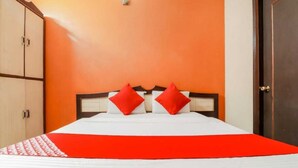 A hotel room with a bed, two red pillows, and a red bedspread. - Hotel Sunrise Lucknow  (Lucknow)