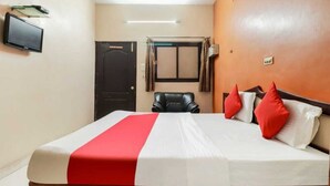 A hotel room with a bed, a television, a door, and a window with curtains. - Hotel Sunrise Lucknow  (Lucknow)