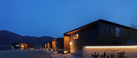 Experience serene mountain views from this tranquil hotel, surrounded by a paved walkway and distant mountains.