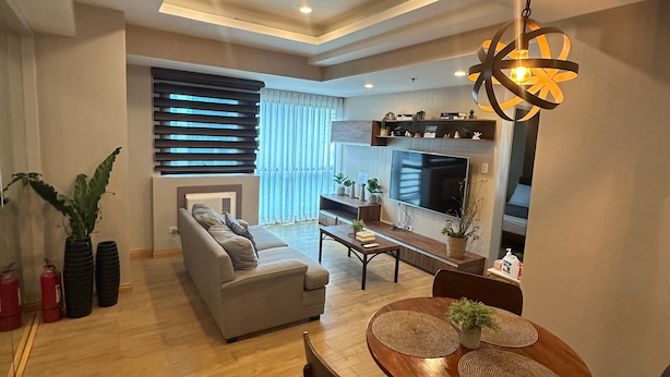A modern living room with a sofa, dining table, and a TV.