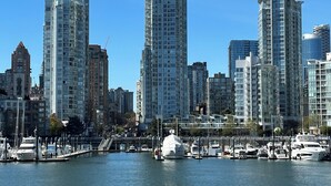 A marina with several boats docked, surrounded by high-rise buildings.