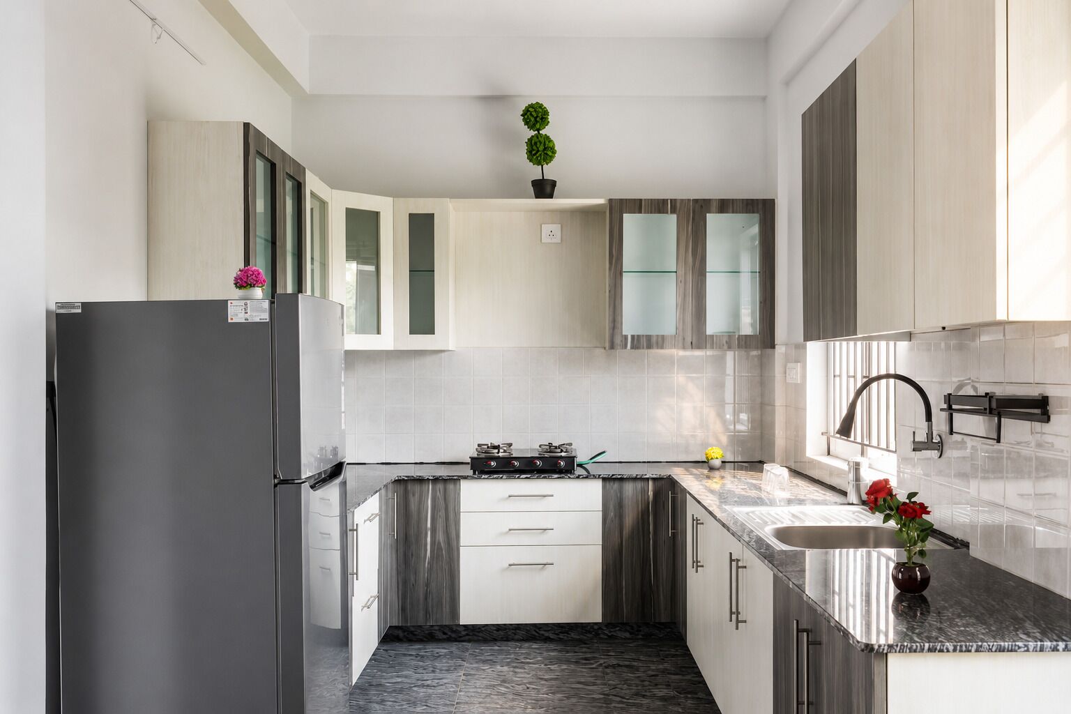 A modern kitchen with a refrigerator, stove, and sink.