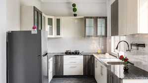 A modern kitchen with a refrigerator, stove, and sink. - Galaxy 4th Block by Red Olive (Bengaluru)