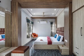 Ein modernes Schlafzimmer mit einem Bett, einer hölzernen Bank, einem Stuhl und einem Kleiderschrank.