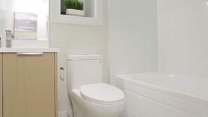 Een badkamer met toilet, wastafel en bad.
