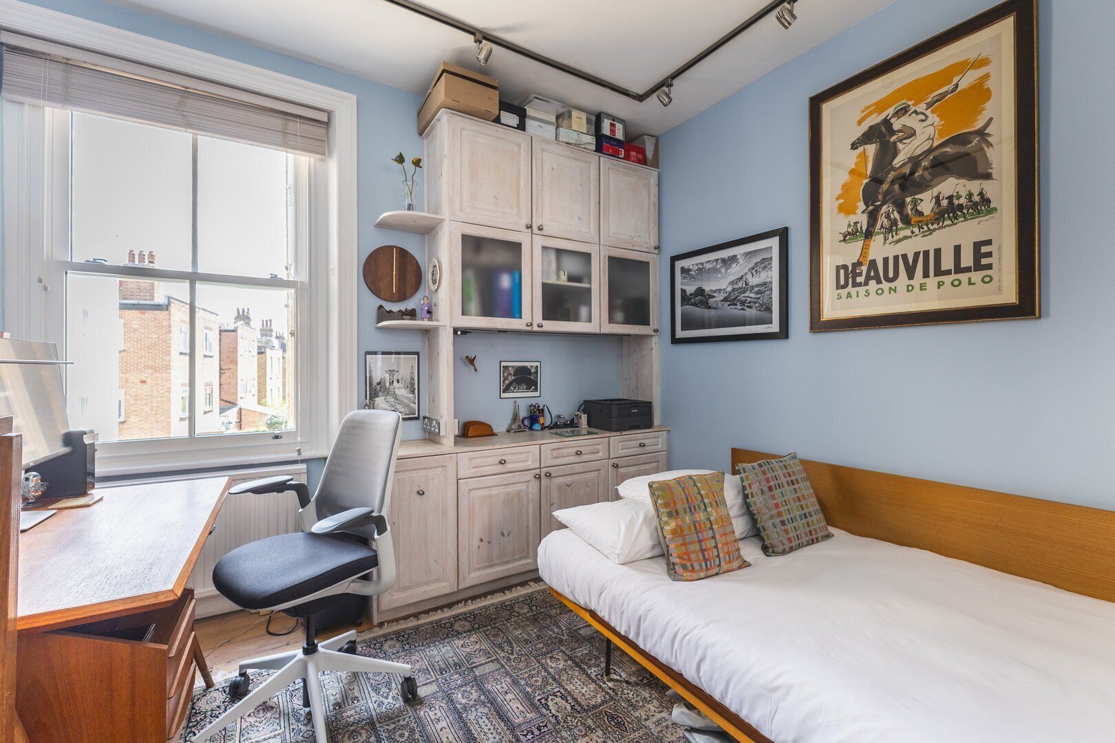 Un dormitorio con cama, escritorio, silla y armario.