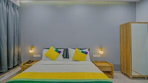 Ein Schlafzimmer mit einem Bett, zwei Nachttischen, einem Kleiderschrank und einem Vorhang.