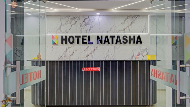 Ein Empfangsschalter mit einer Marmorwand und einem Schild mit der Aufschrift 'HOTEL NATASHA'.