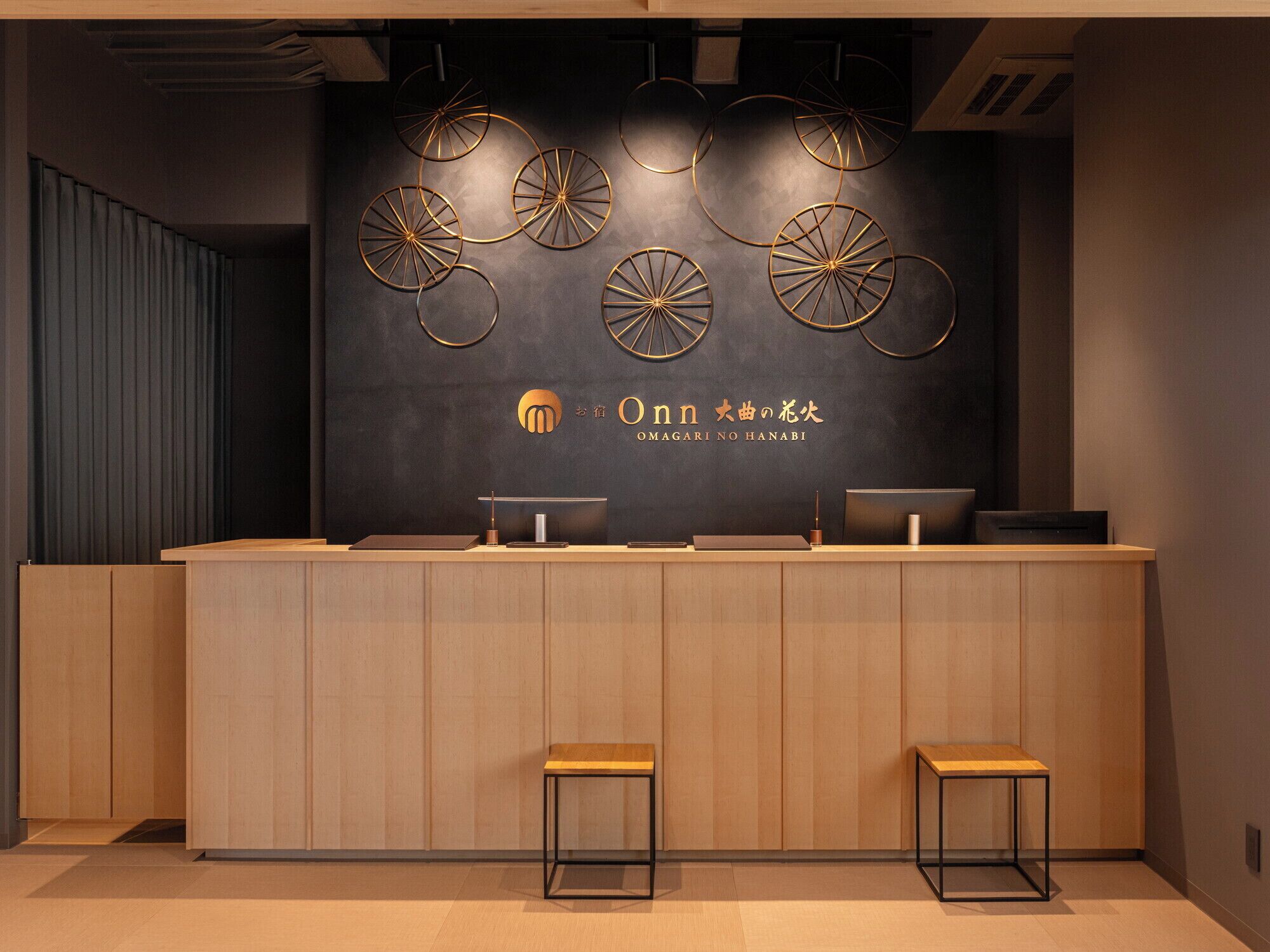 A reception desk with a dark wall and circular wall decor.