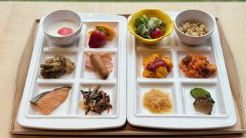 A meal tray with various food items including salmon, vegetables, and a salad.