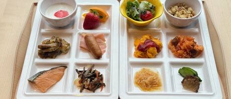 A meal tray with various food items including salmon, vegetables, and a salad.