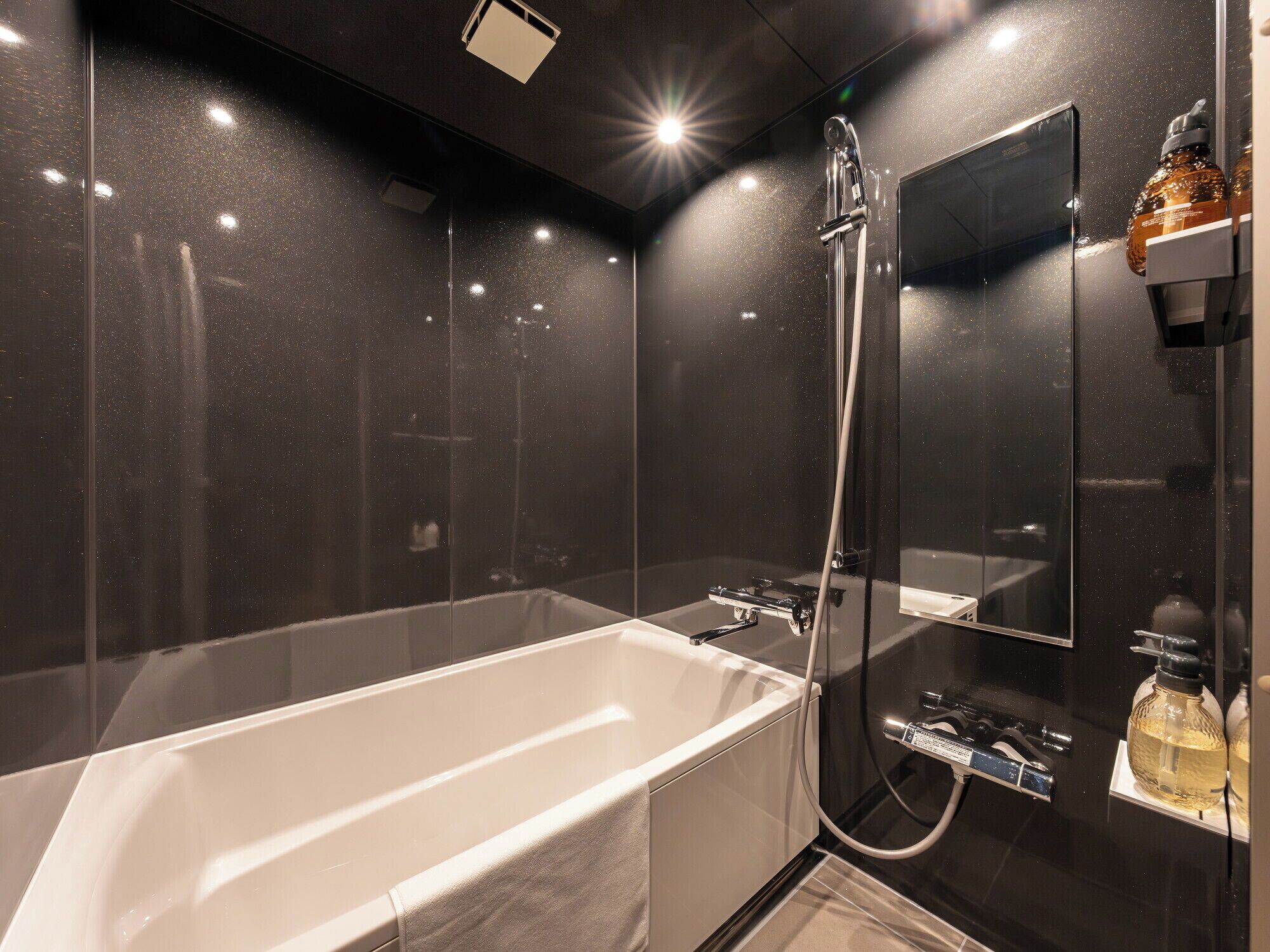 Ein modernes Badezimmer mit einer großen Badewanne, einer Dusche und einem Spiegel.