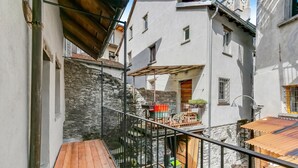 A narrow alleyway with a wooden deck, stone walls, and a metal railing. - Ca dal 1785 Centovalli With Balcony and Parking (Centovalli)