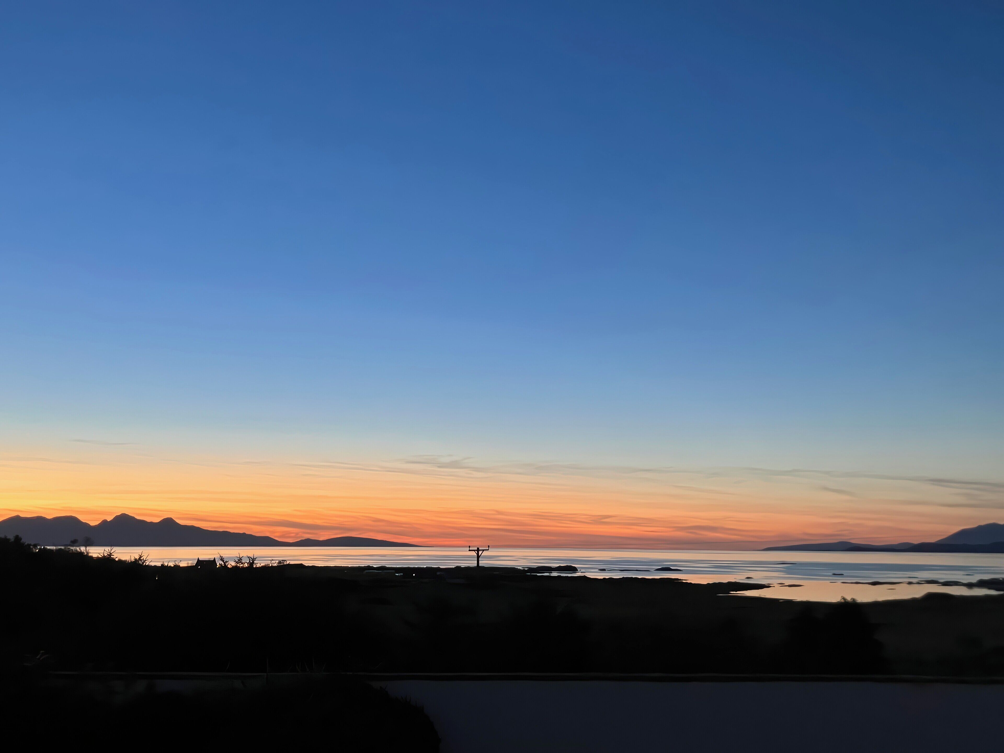 Un paysage côtier avec un ciel dégagé au coucher du soleil.