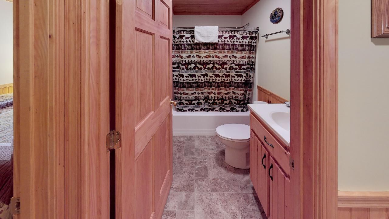 Un baño con bañera, inodoro y muebles de madera.