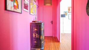 A hallway with pink walls, wooden flooring, and a door at the end. - Large apartment tastefully decorated for 5 people (Les Sables-d´Olonne)