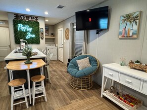 Enjoy a homey atmosphere in this cozy space, featuring a bar counter, stools, and a flat-screen TV.
