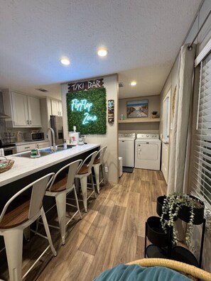 Enjoy cooking and dining at the central island with a stove, sink, and microwave, surrounded by comfortable bar stools.