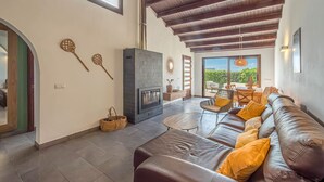 Un salón amplio con chimenea, sofá de cuero y vistas al exterior.