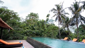 A pool area with lounge chairs and a wooden deck. - Umah Temuku Ubud (Ubud)