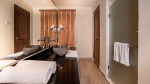 A modern bathroom with two sinks, wooden doors, and a towel rack. - Umah Temuku Ubud (Ubud)