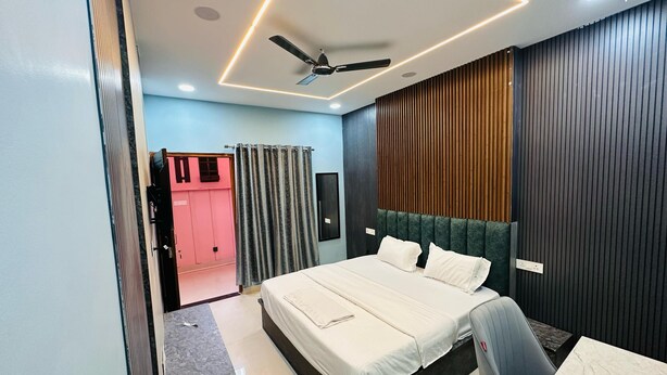 Une chambre à coucher moderne comprenant un lit, un bureau, une chaise, un ventilateur de plafond et une armoire.