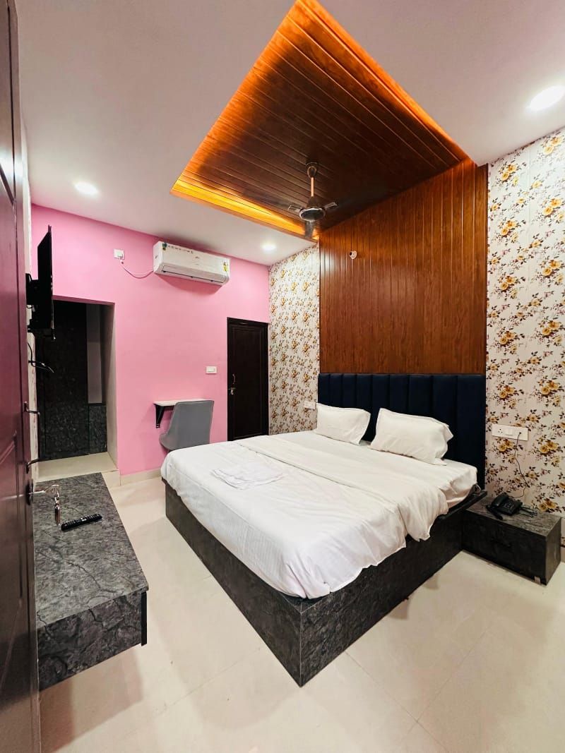 A modern bedroom with a large bed, a vanity with a mirror, and a ceiling fan.