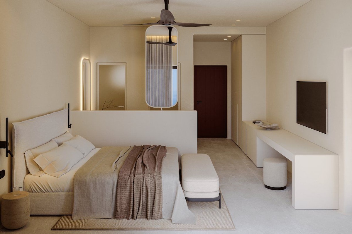 A modern bedroom with a bed, bedside table, bench, and a large mirror.