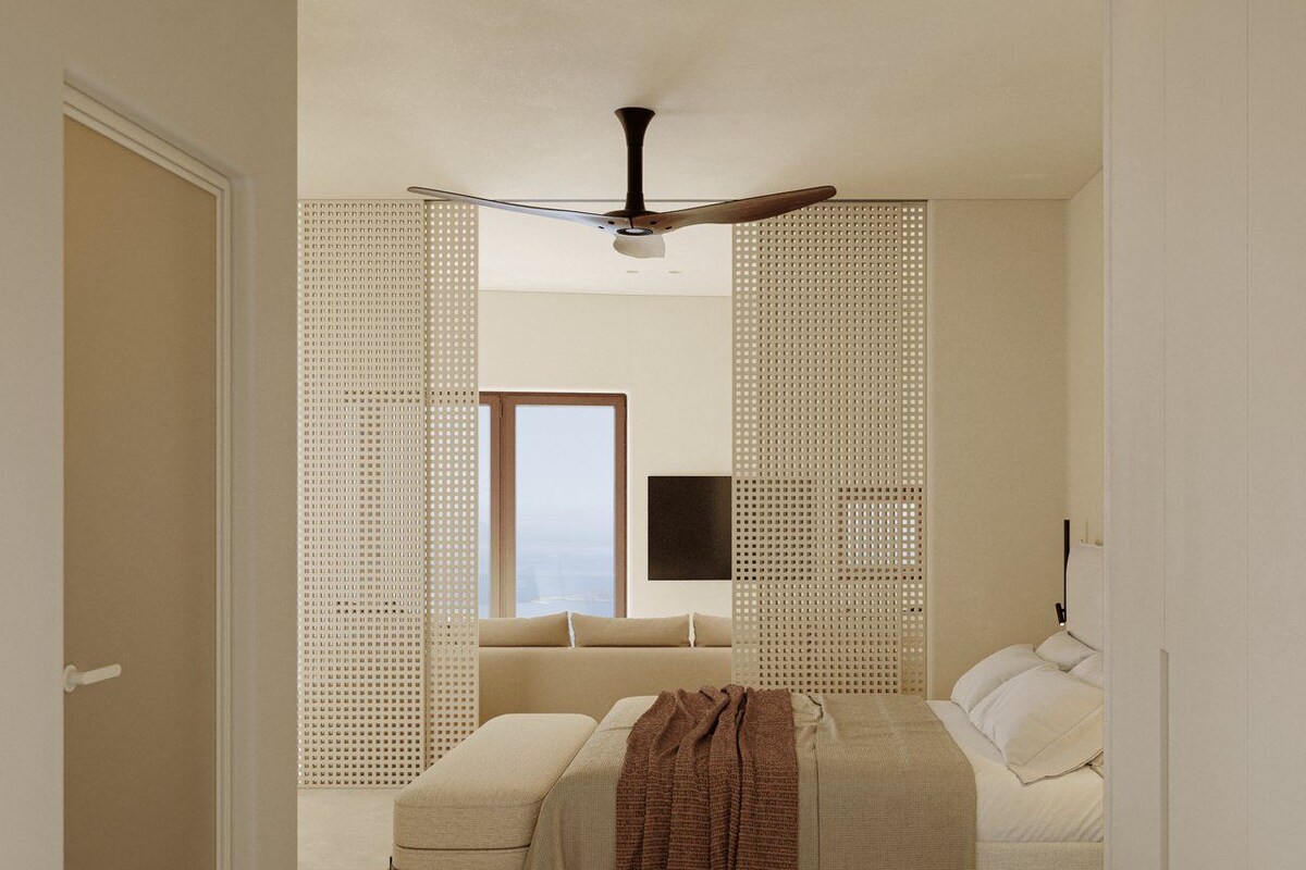 Un dormitorio con cama, ventilador de techo, ventana y vista a la ciudad.