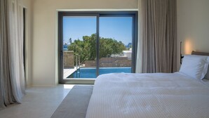 Un dormitorio con una cama grande, vistas a una piscina y una puerta corrediza de vidrio.