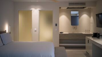 Ein Hotelzimmer mit Bett, Schreibtisch, Spiegel und Deckenventilator.