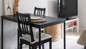 Un espace repas comprenant une table, des chaises, un téléviseur et des œuvres d’art murales.